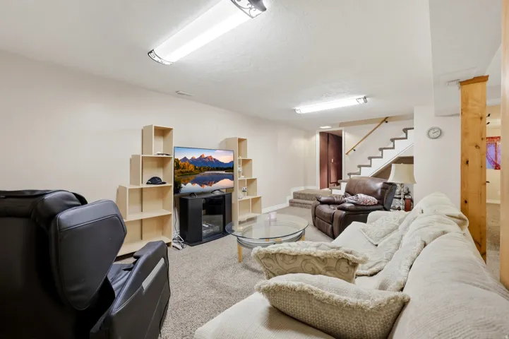 Carpeted flooring throughout, light-toned walls, and a wood-finish structural column