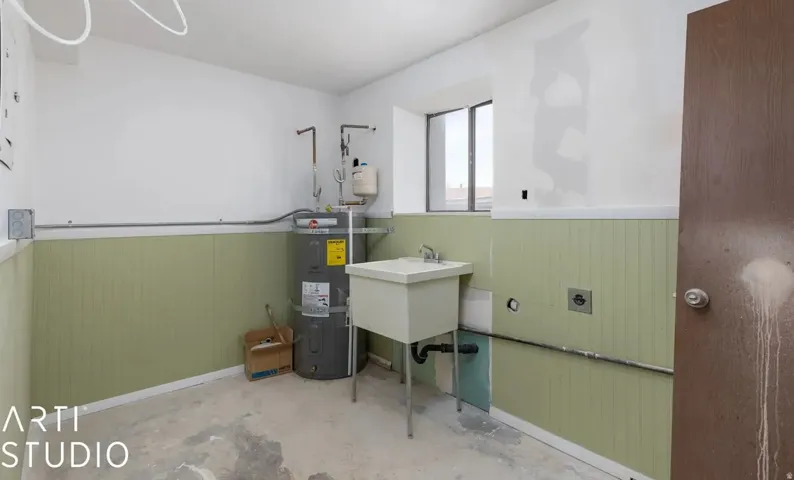 Utility room with a sink basin, water heater, and paneling