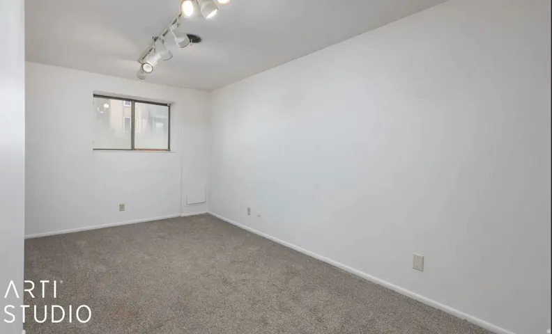 Recessed window with track lighting, and grey carpet flooring
