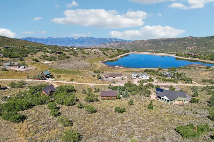 Mountainous terrain with a prominent lake, surrounded by scattered residential properties