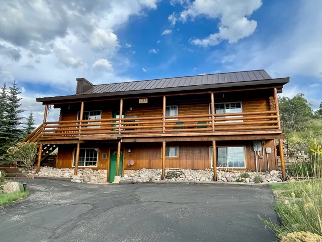 Wood-sided exterior with a metal roof and a full-length upper-level balcony