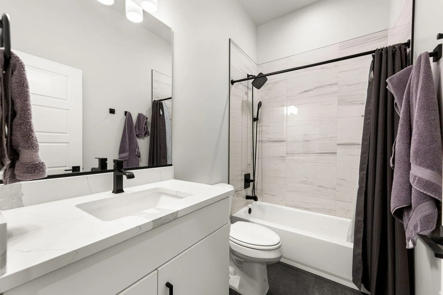 White vanity with integrated rectangular sink and stone-finish countertop