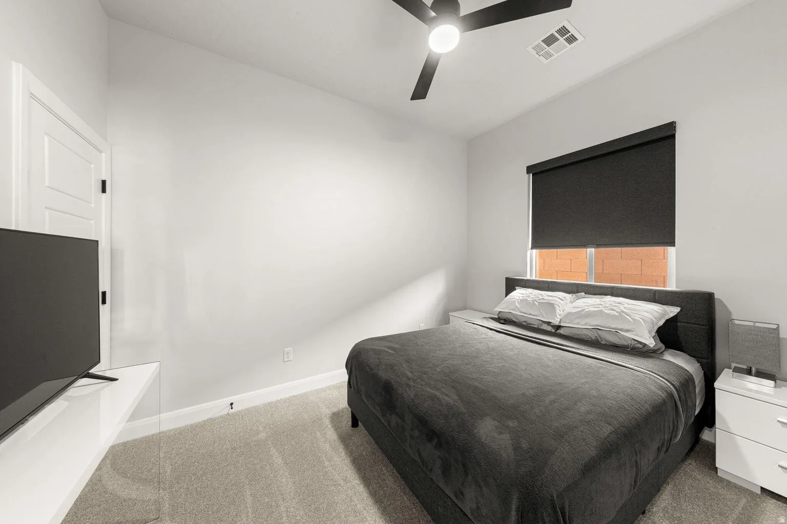 Plush carpet flooring, a modern ceiling fan, and a neutral wall palette