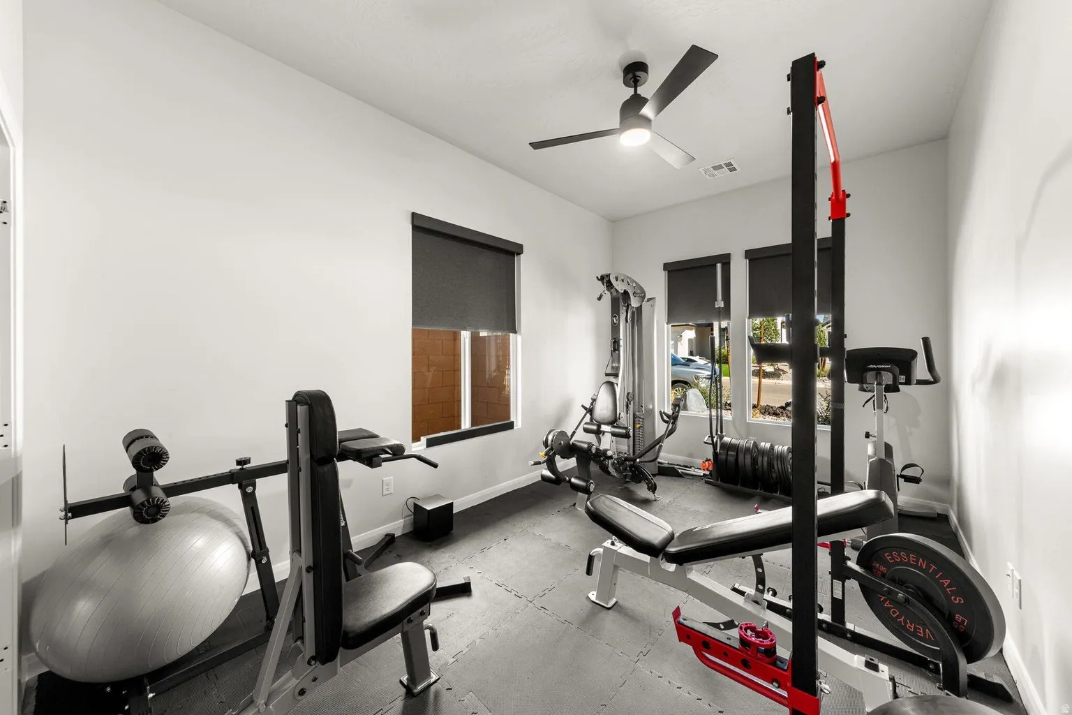 Recessed lighting, ceiling fan, multiple windows with roller shades, and light-toned walls