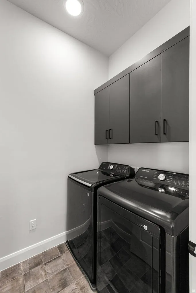 Recessed ceiling lighting, built-in dark cabinetry, and tile flooring