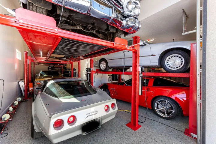 Garage featuring multiple vehicle lifts, epoxy flooring, and recessed ceiling lighting