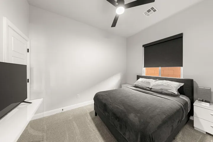 Plush carpet flooring, a modern ceiling fan, and a neutral wall palette