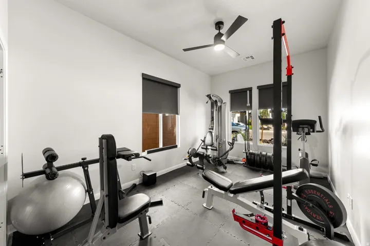 Recessed lighting, ceiling fan, multiple windows with roller shades, and light-toned walls