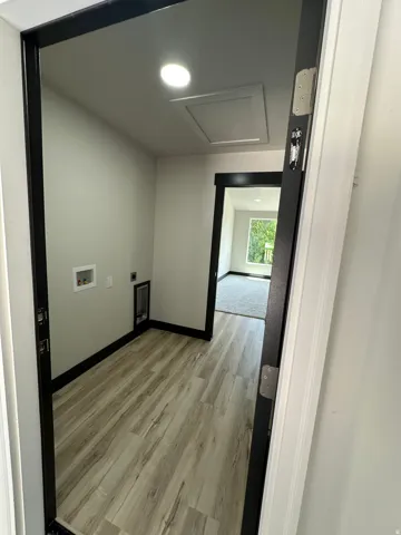 Utility space with wood-finish flooring, recessed lighting, and dark trim