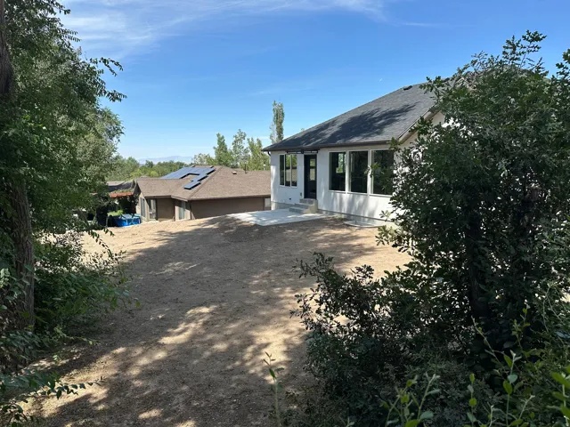 Expansive property featuring a newly constructed exterior, multiple large windows, and a concrete patio