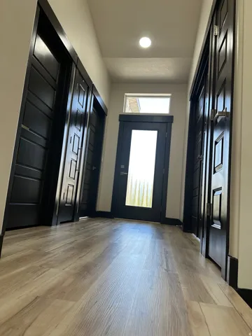Wood-finish flooring throughout, complemented by dark interior doors with panel details