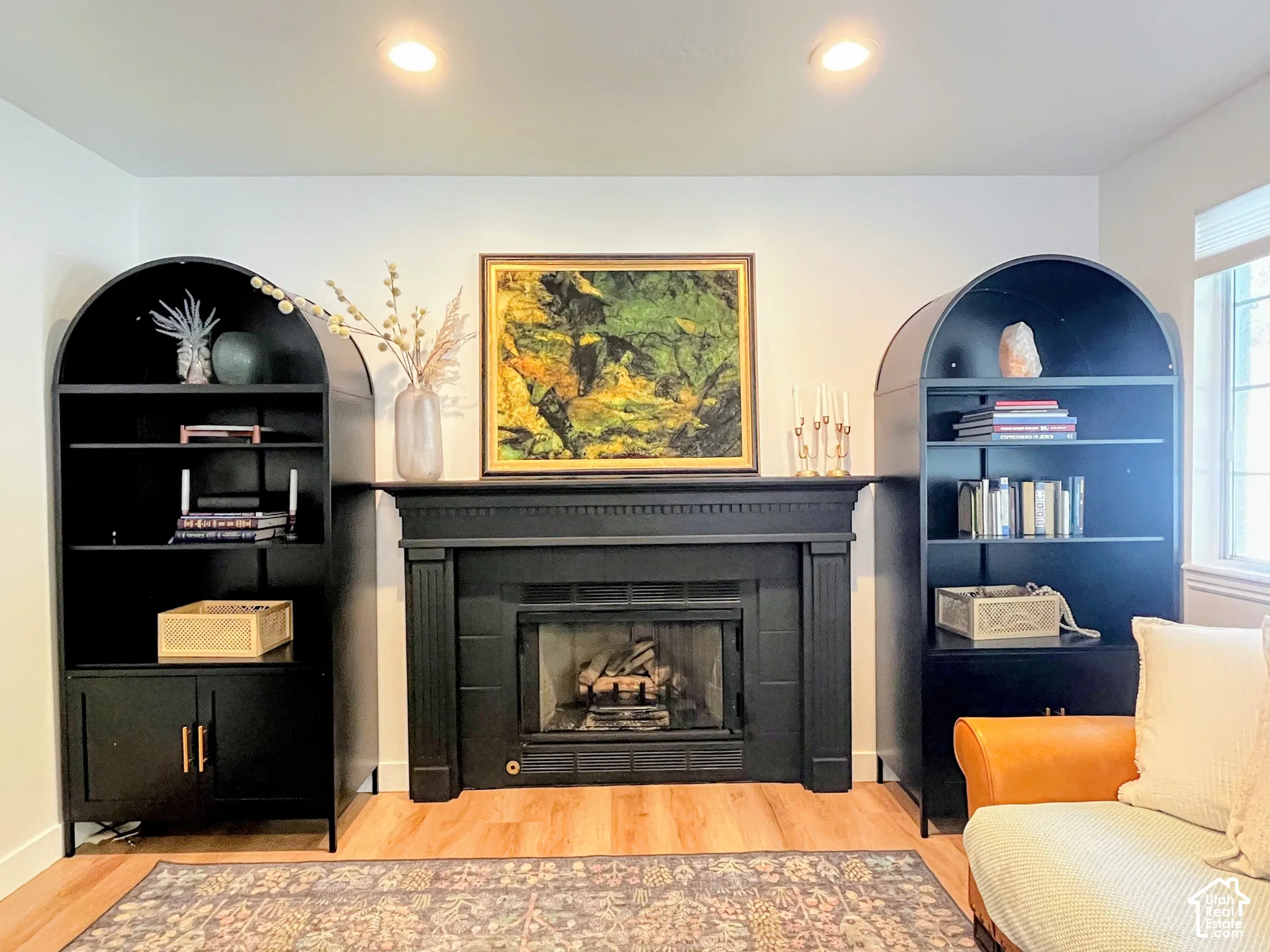 Fireplace featuring a black mantel, recessed lighting, and wood-finish flooring