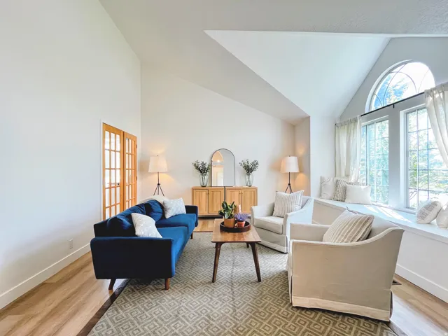 Vaulted ceilings, wood-finish flooring, arched window, built-in window seating, and interior French doors