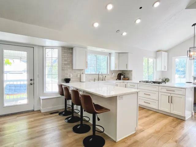 Modern kitchen featuring wood-finish flooring, white cabinetry, a built-in kitchen island, and recessed lighting