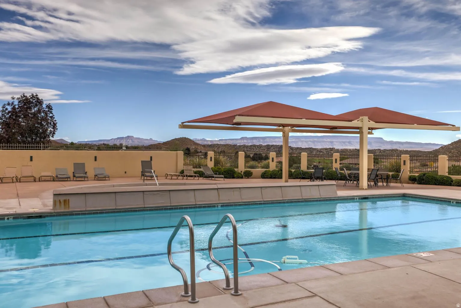 Swimming pool with integrated steps, surrounded by a paved deck