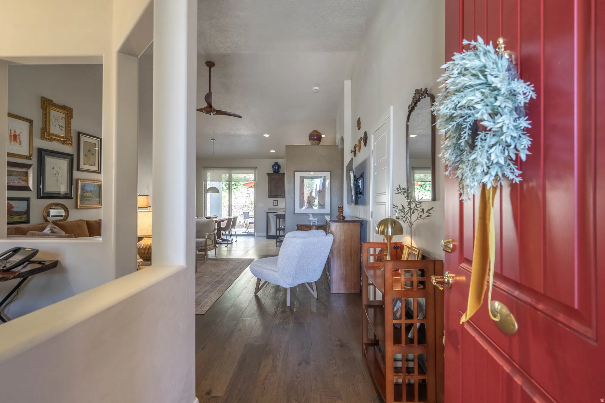 Red paneled entry door with brass hardware, wood-finish flooring, recessed lighting, and ceiling fan