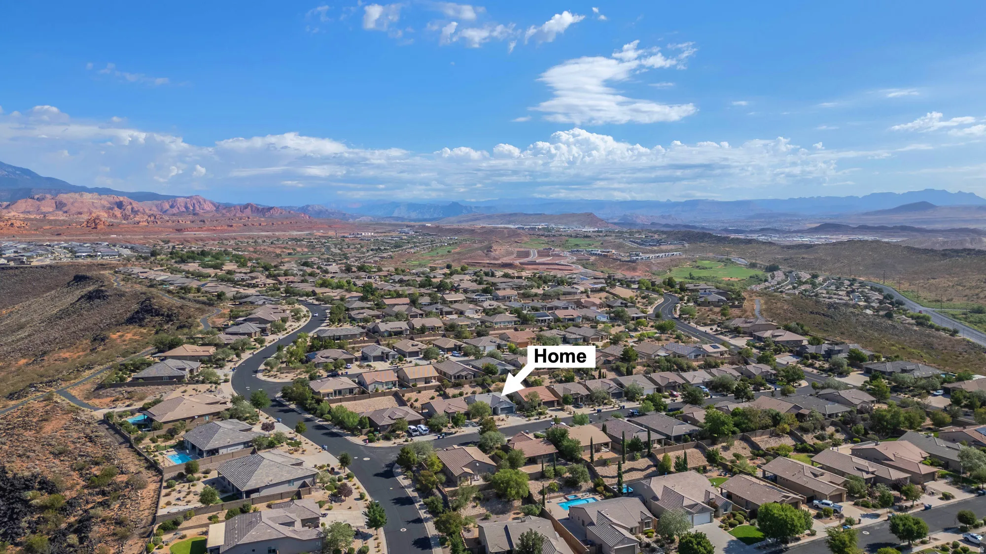 Residential neighborhood with varied rooflines and surrounding arid landscape