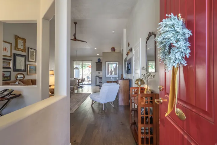 Red paneled entry door with brass hardware, wood-finish flooring, recessed lighting, and ceiling fan