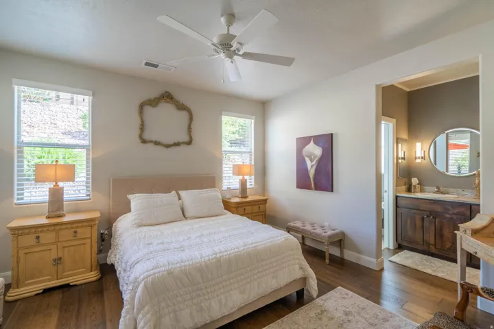 Recessed lighting, wood-finish flooring, ceiling fan, and en-suite bathroom featuring a vanity with a counter and round mirror