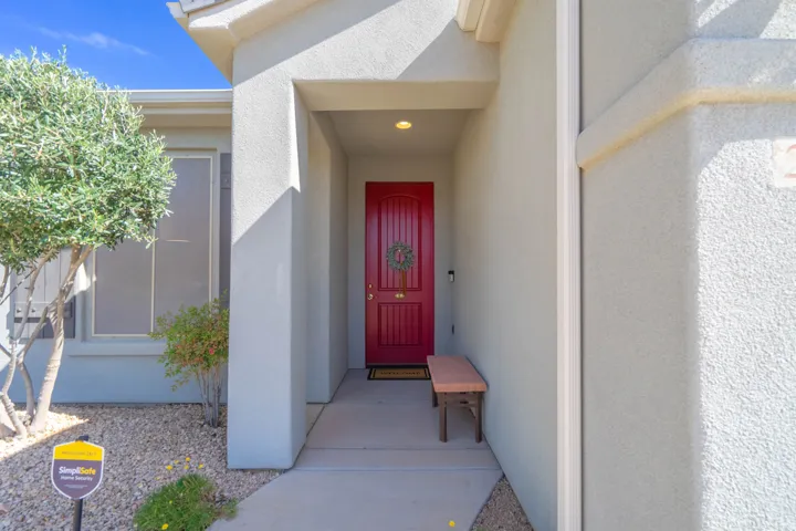 Recessed entry with a paneled red door, stucco exterior, and accent trim