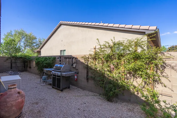 Gravel patio area featuring a block perimeter wall and established climbing plants