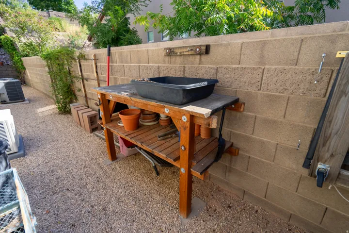 Private outdoor space with a gravel surface, surrounded by a durable concrete block wall