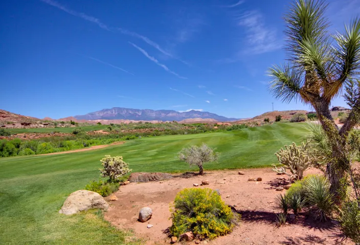 Expansive golf course frontage with manicured greens, natural desert landscaping, and distant mountain ranges