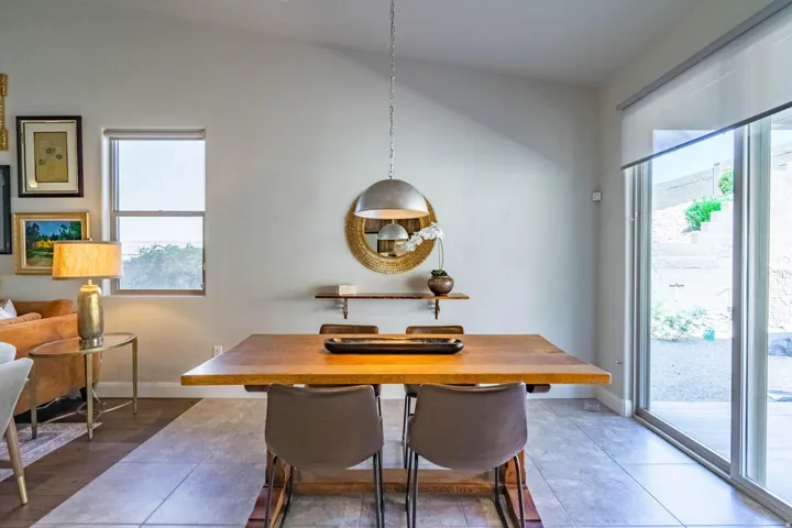 Vaulted ceiling, recessed lighting, tile flooring, wood-finish dining table, and sliding glass doors to the exterior