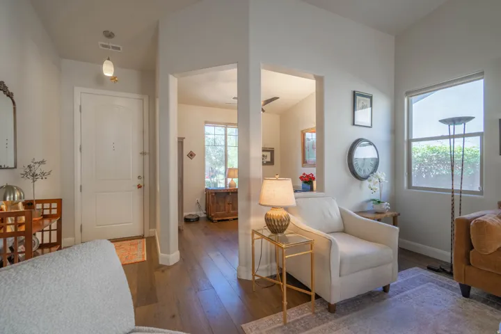 Arched interior doorways, wood-finish flooring, a ceiling fan, and high ceilings
