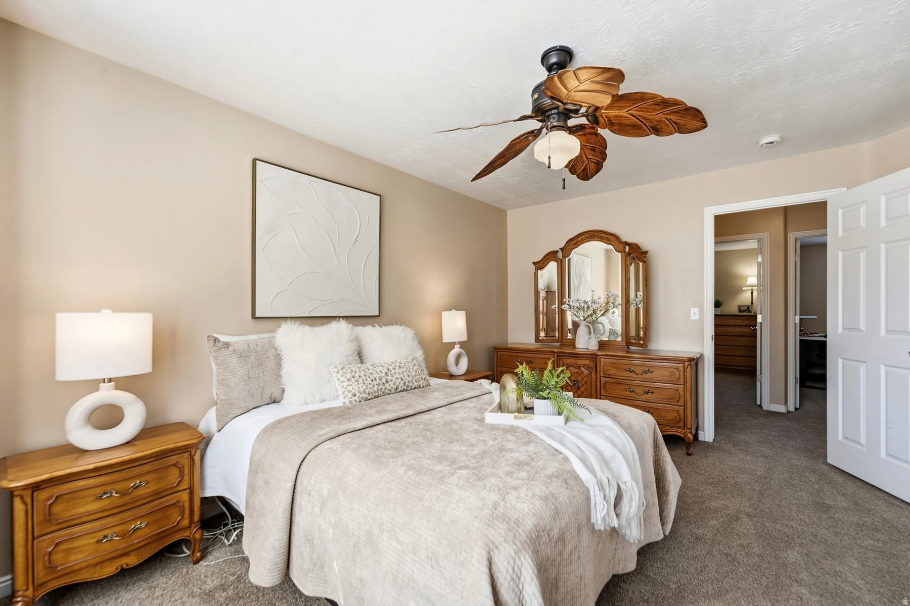 Carpeted bedroom with a ceiling fan, neutral wall finishes, and a white paneled door