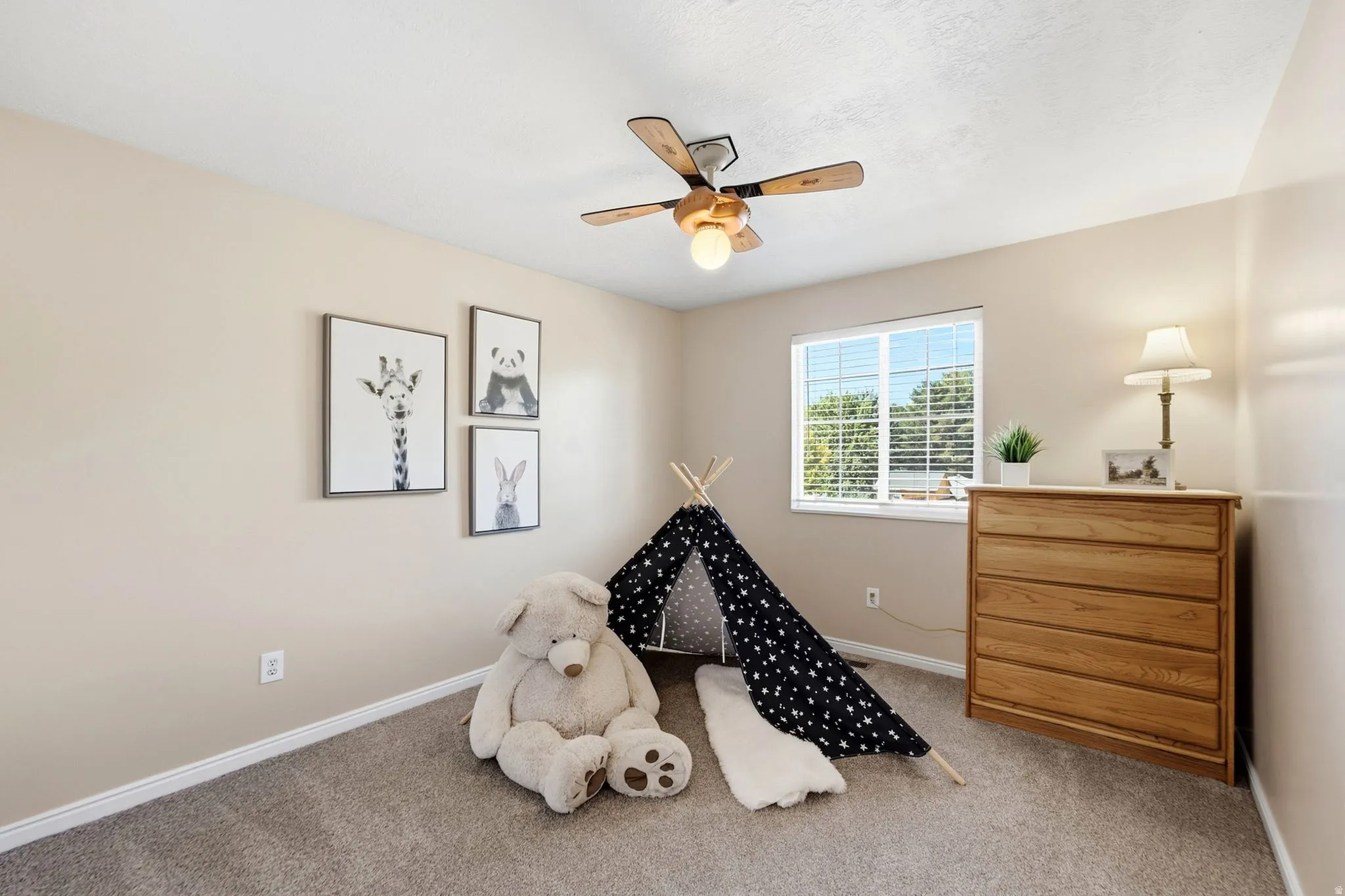 Carpeted room featuring a ceiling fan with light, a window with blinds, and light-toned walls