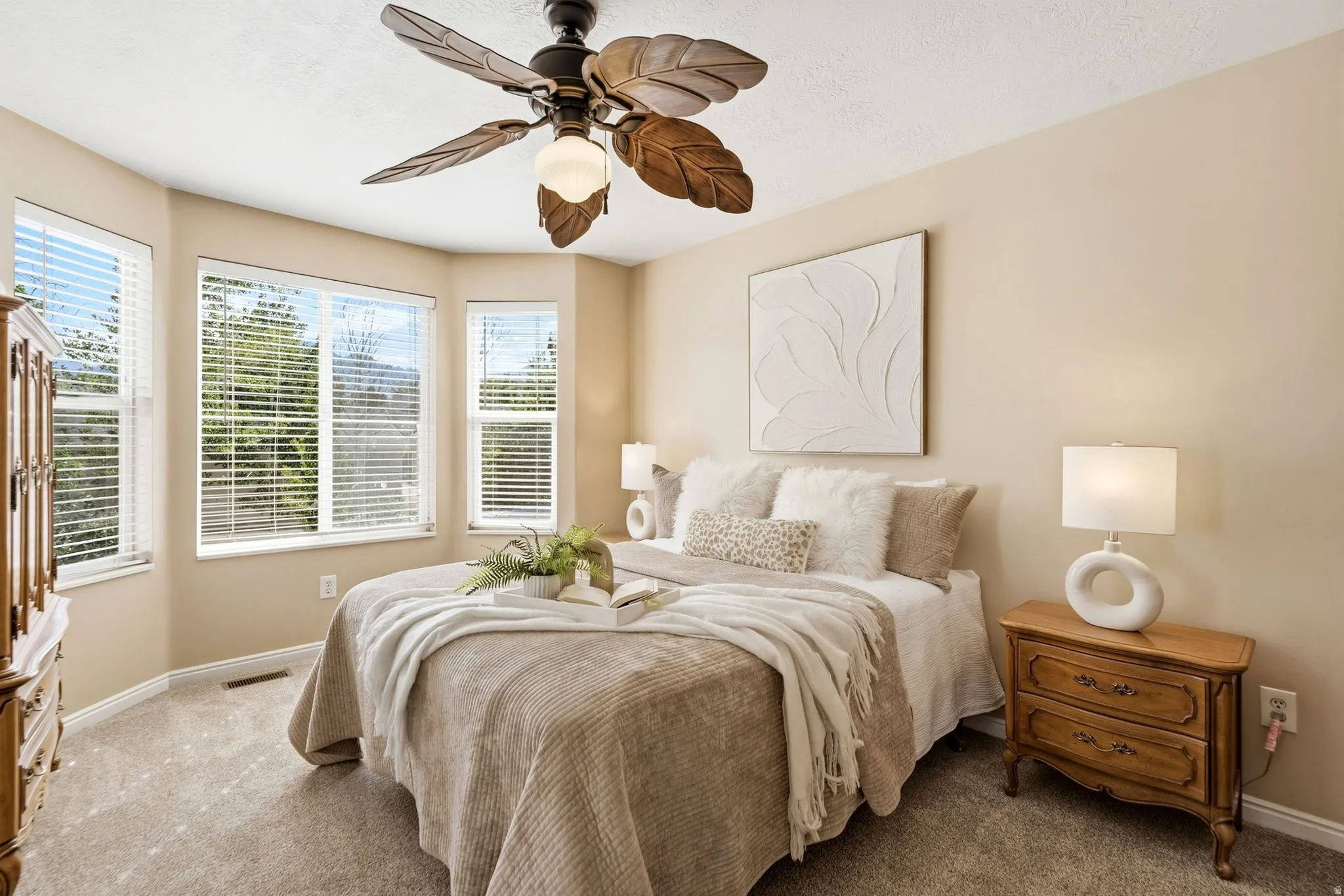 Primary bedroom featuring a bay window letting in abundant light and allowing for a peek at the Wasatch mountains.