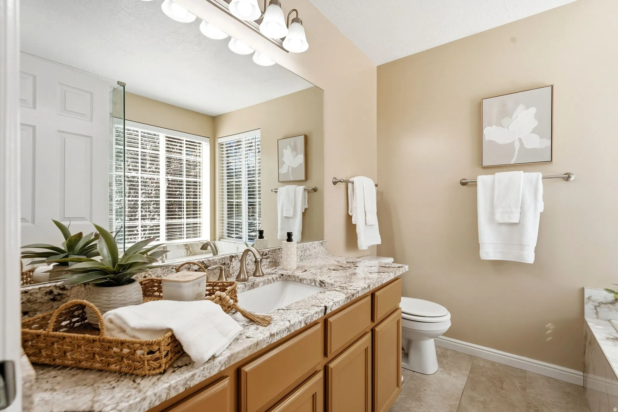 Double vanity with an integrated sink, granite-style countertop, and wood-finish cabinetry