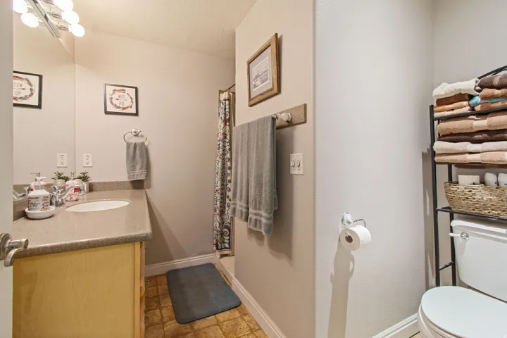 Vanity with integrated sink, chrome faucet, and overhead bar lighting