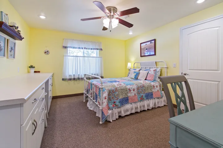 Recessed ceiling lighting, a wood-blade ceiling fan, and carpeted flooring