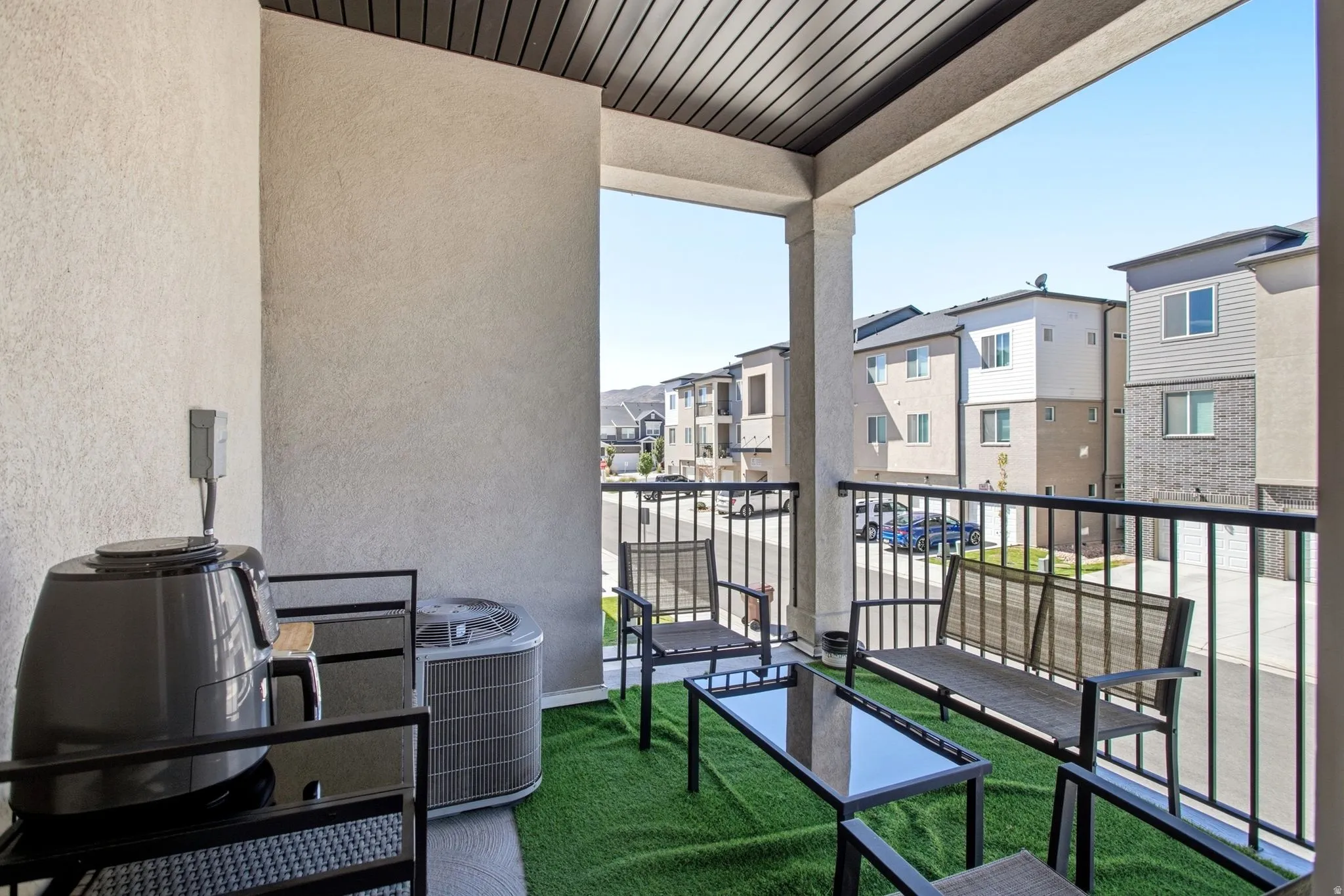 Covered balcony featuring a textured wall finish and a slatted ceiling