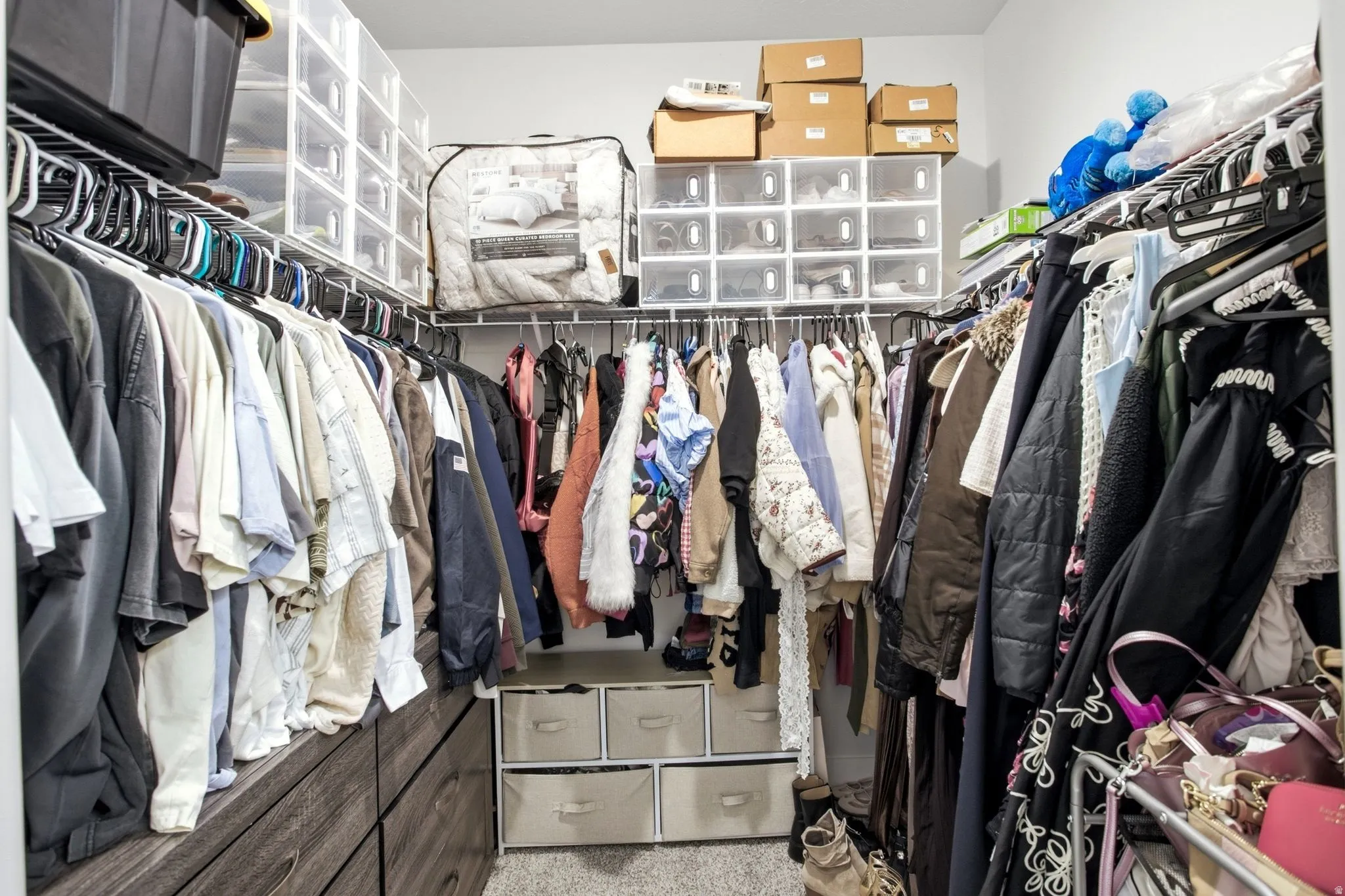 Walk-in closet featuring built-in wood-finish drawers, wire shelving, and carpet flooring