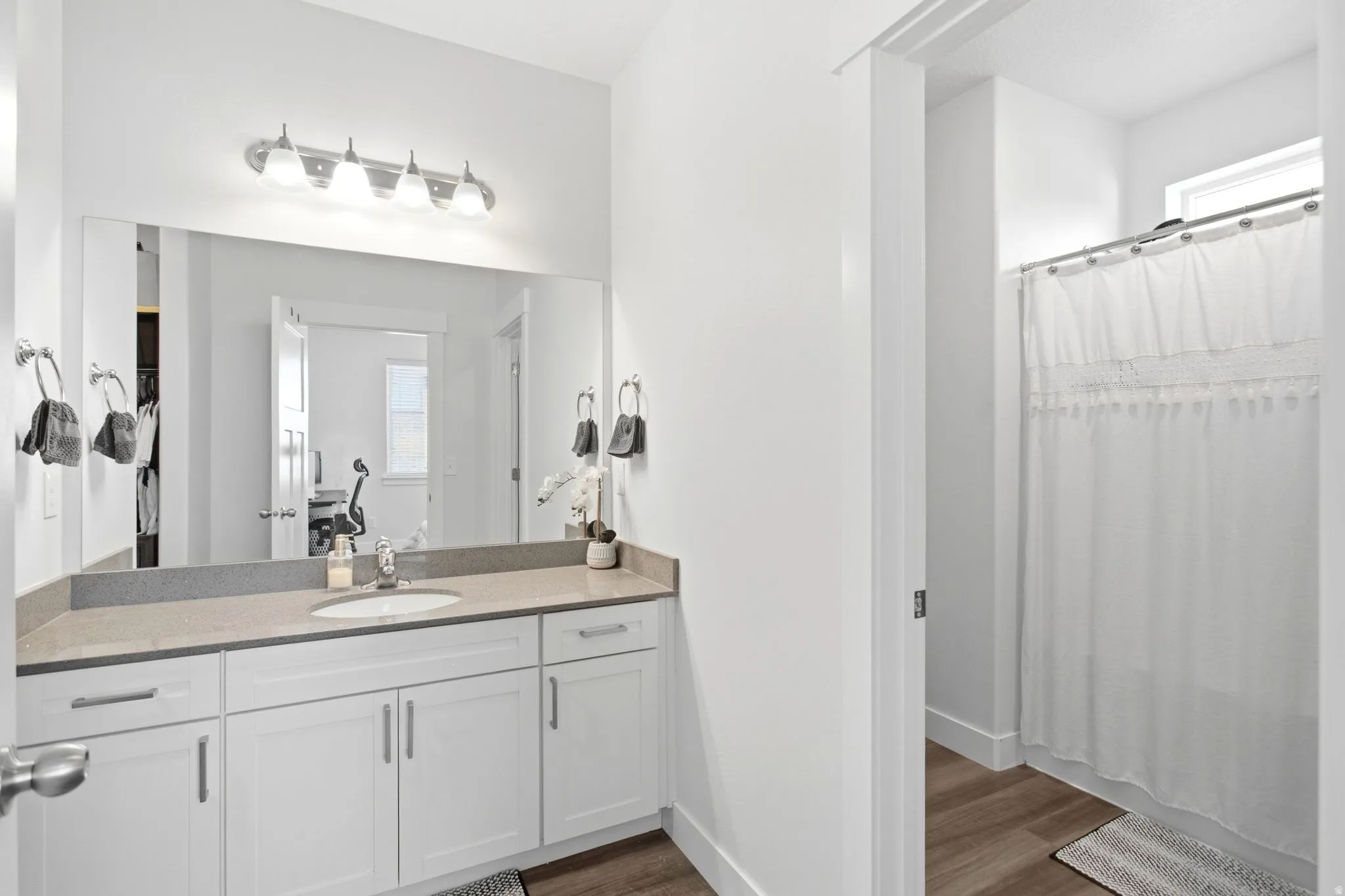 Vanity with integrated sink, stone-finish countertop, and white cabinetry
