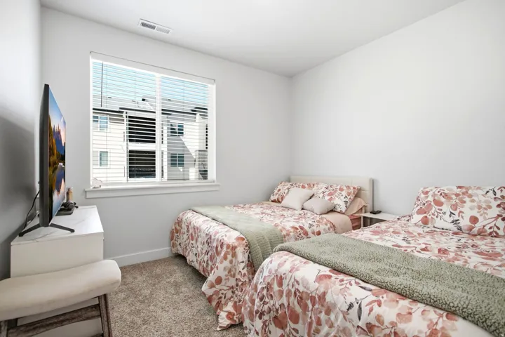 Carpeted flooring, white walls, and a window with blinds