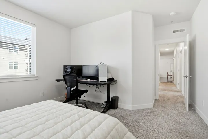 Window with horizontal blinds, light-colored walls, and gray carpet