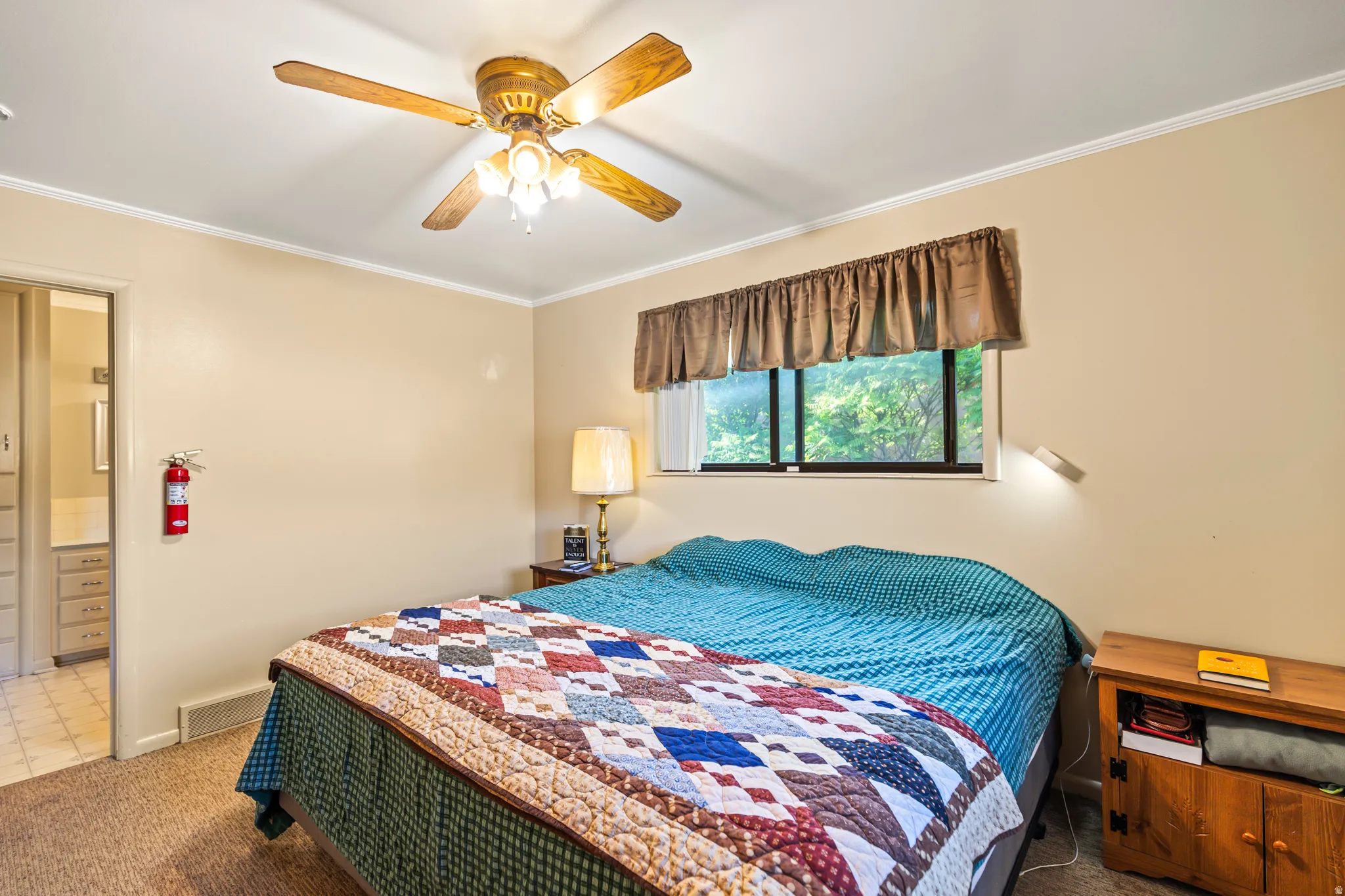 Carpeted room with a ceiling fan, recessed window, and cream-colored walls