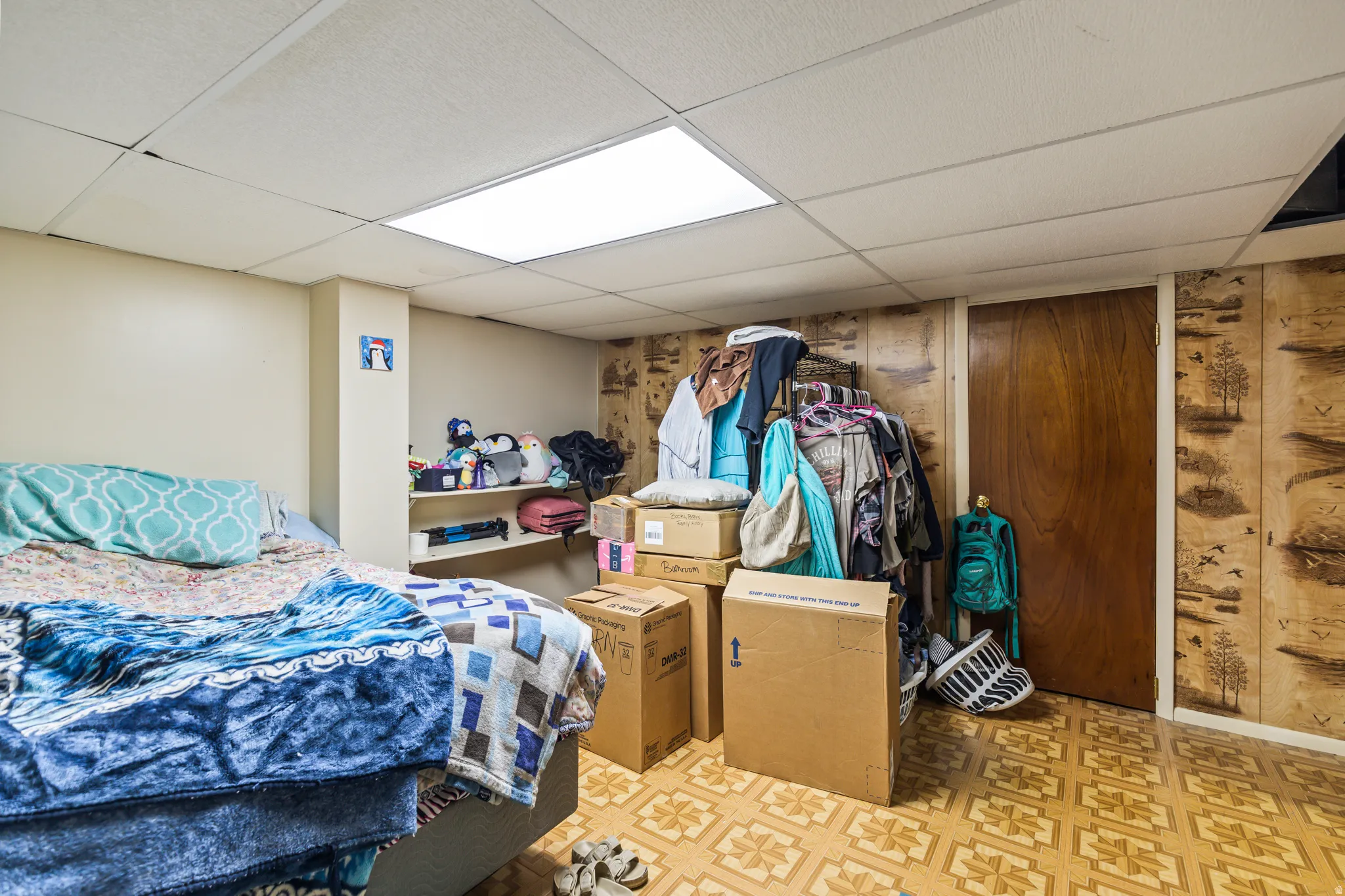 Recessed ceiling lighting, drop ceiling, wood-finish paneling, and a wood door