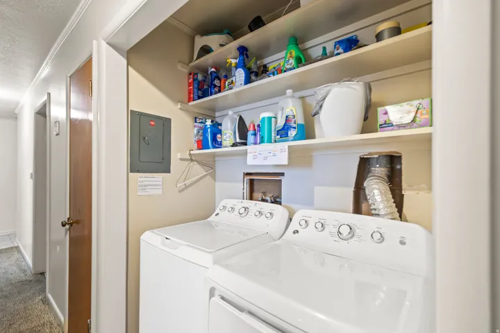 Laundry area with stacked shelving and built-in washing machine and dryer