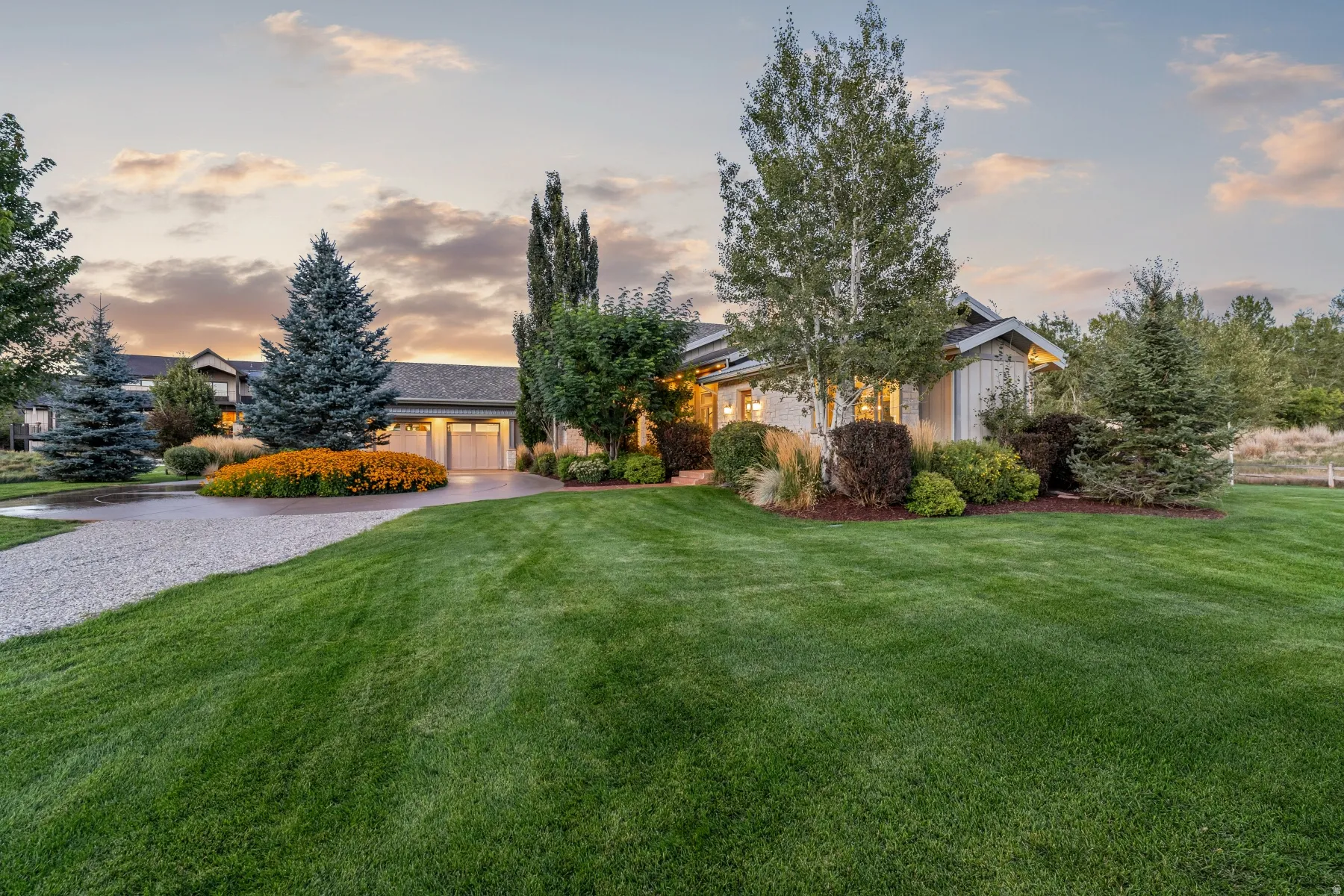 Expansive manicured lawn with mature trees and professional landscaping