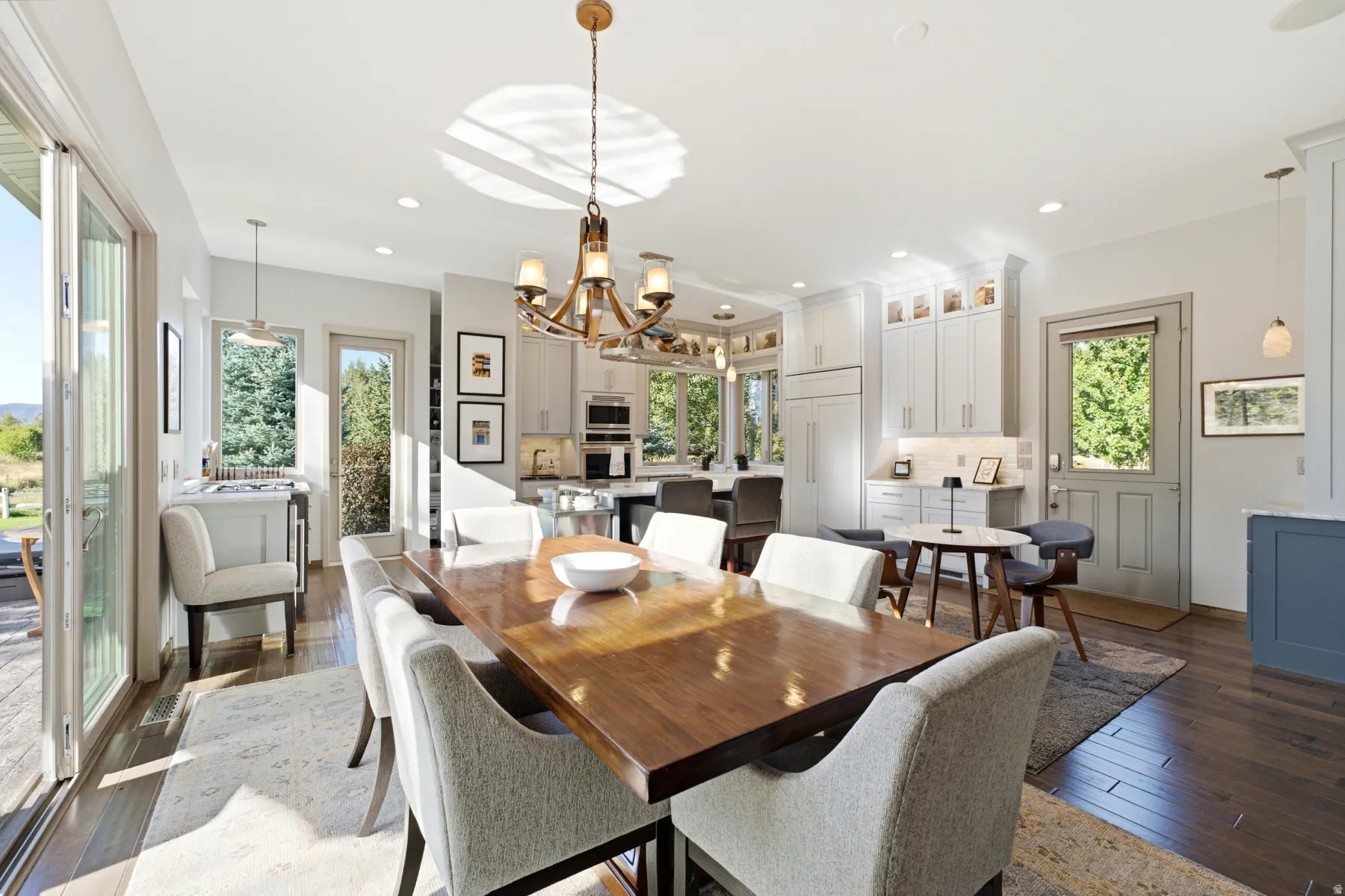 Hardwood flooring throughout, with a wood-finish dining table and a multi-light chandelier