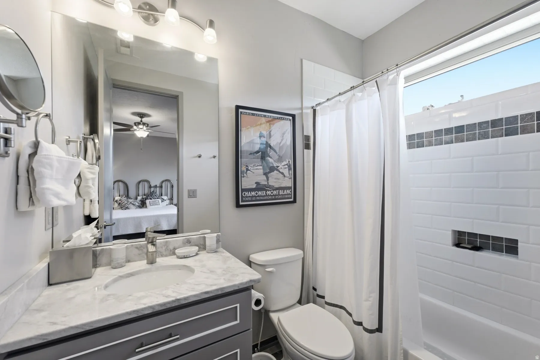 Bathroom featuring a single vanity with a stone countertop, a rectangular sink, and a framed mirror