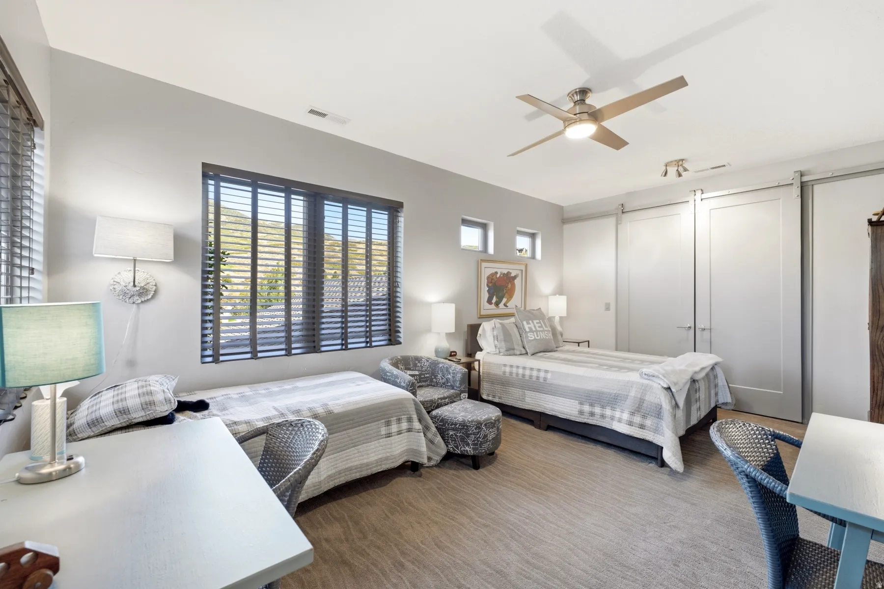 Room featuring a ceiling fan with integrated lighting, wood-finish flooring, and multiple windows with blinds