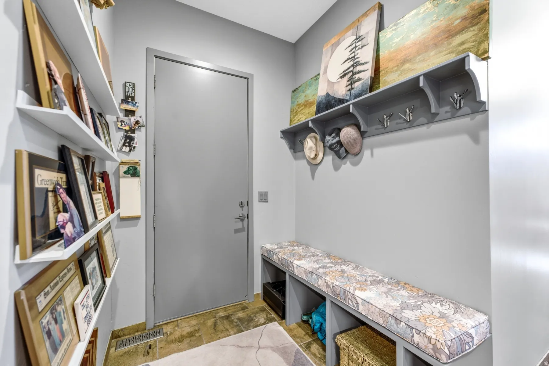 Entry area featuring built-in shelving, a full-height door, and a built-in bench with open storage compartments