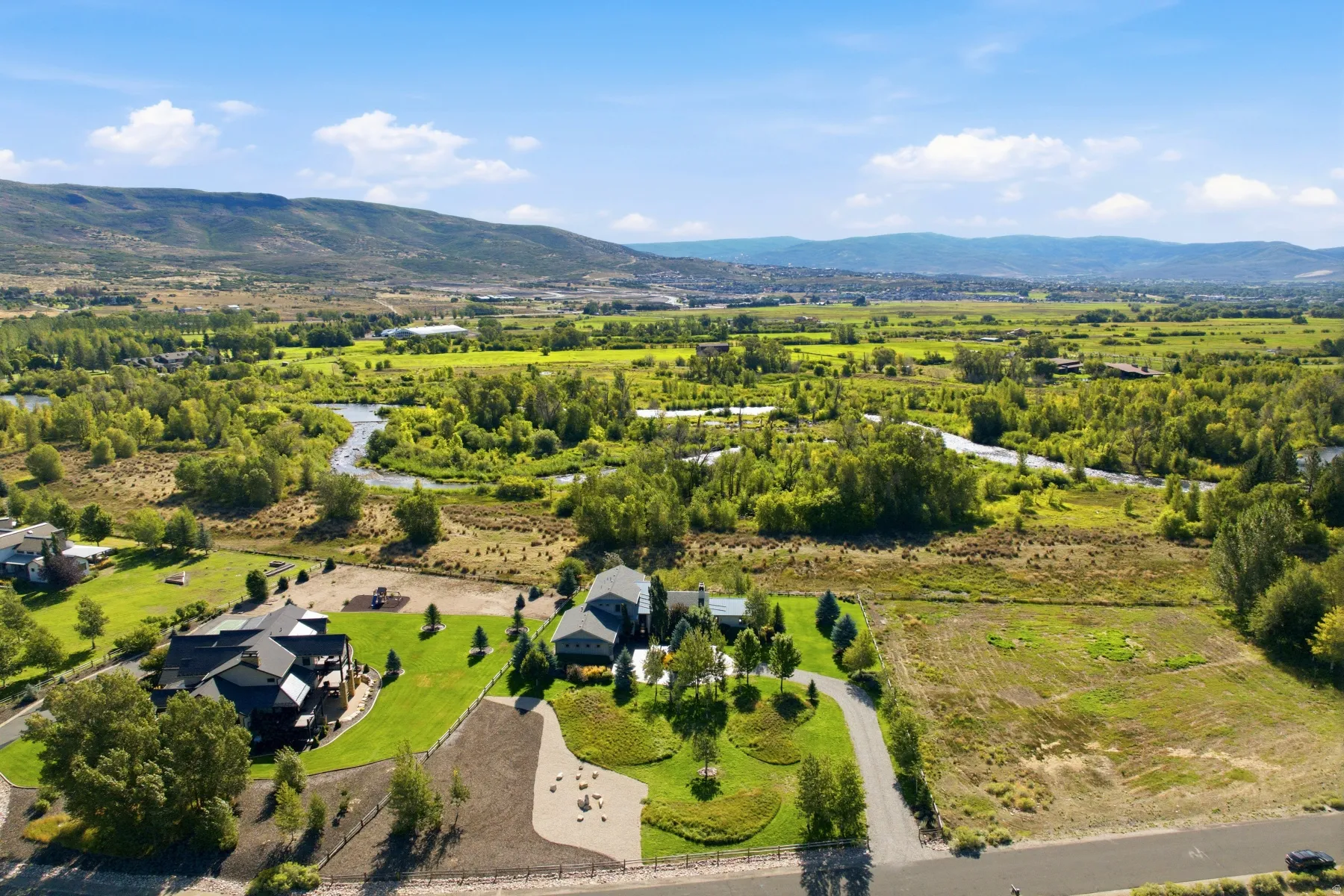 Expansive property featuring a river, mature trees, and mountainous terrain