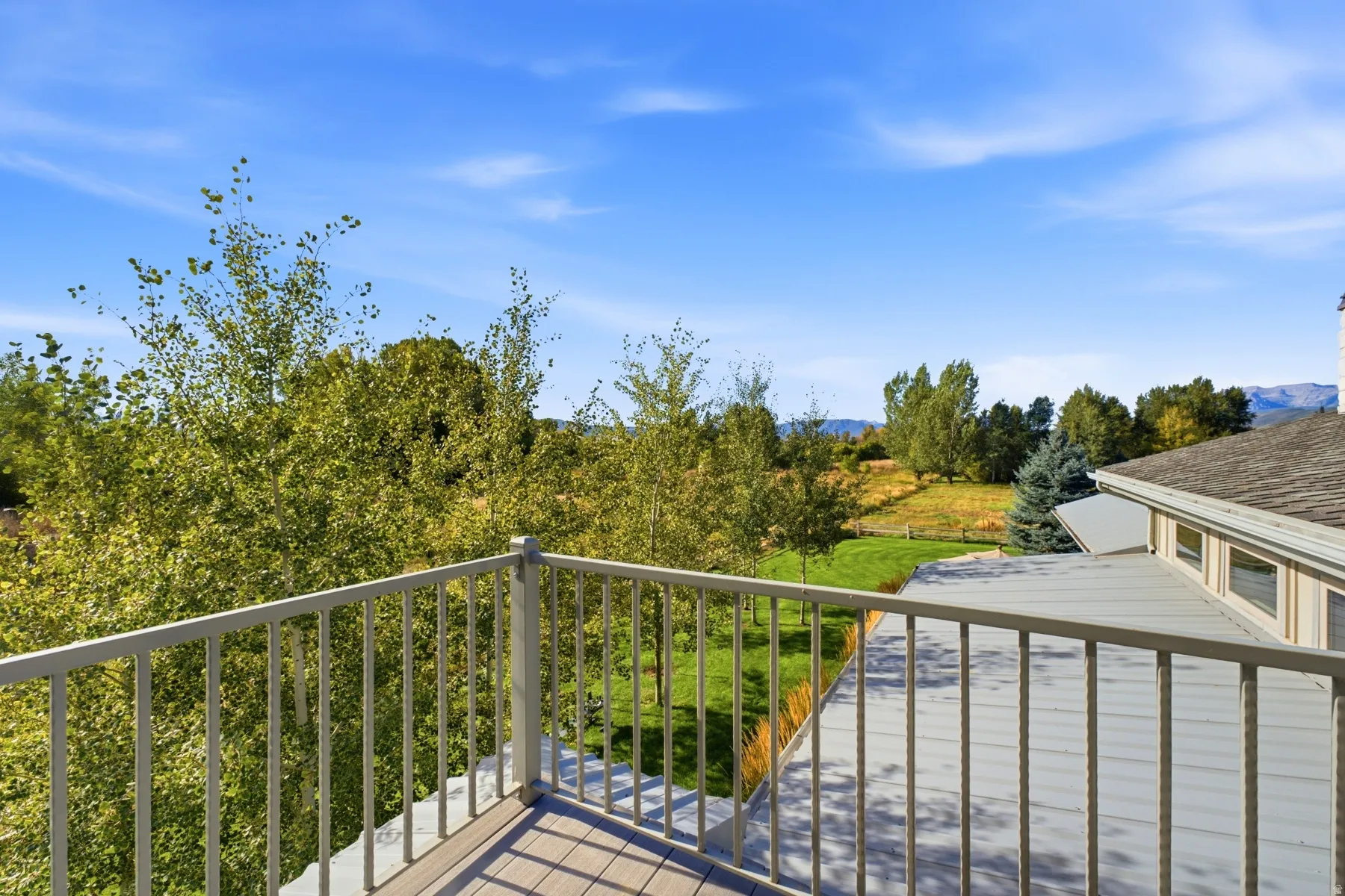 Exterior deck with composite decking, aluminum railing, and expansive tree-lined scenery
